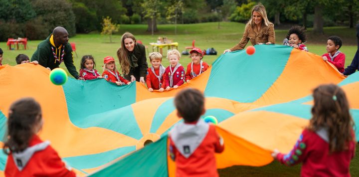 La primera dama de Estados Unidos, Melania Trump, y la princesa Catalina de Gales, de Gran Bretaña, agitan un paracaídas lleno de pelotas con un grupo de chicos de la Asociación Scout en Frogmore Cottage, en la finca de Windsor, durante la segunda visita de Estado del presidente estadounidense Donald Trump.