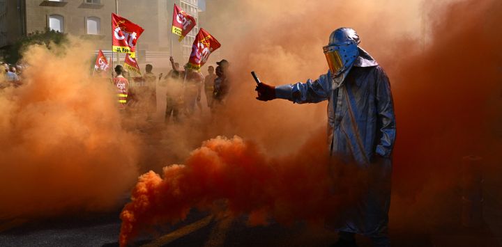 Un manifestante enciende bengalas en Marsella, sureste de Francia, durante una jornada de huelgas y protestas a nivel nacional convocadas por los sindicatos contra el presupuesto nacional francés.