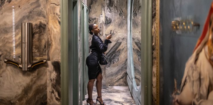 Una clienta usa su teléfono para tomarse una foto en el espejo del baño del restaurante, salón y club Rococo en Lagos. En Nigeria, las selfies en el baño no son ninguna broma. Desde la bulliciosa megaciudad de Lagos hasta la sofocante capital, Abuya, y la conservadora Kano en el norte, bares y salones están renovando sus baños, no solo para adaptarse a los nuevos tiempos, sino también para atraer nuevos clientes.