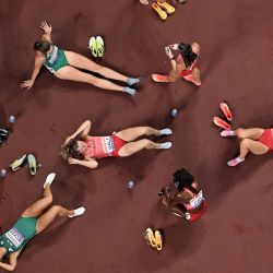 Atletas como la irlandesa Sophie Becker, la canadiense Lauren Gale y la canadiense Zoe Sherar reaccionan después de las eliminatorias del relevo femenino de 4x400 m durante el Campeonato Mundial de Atletismo en Tokio. | Foto:ANTONIN THUILLIER / AFP