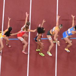 Las atletas esperan la entrega del testigo durante las eliminatorias del relevo femenino de 4x400 m durante el Campeonato Mundial de Atletismo en Tokio. | Foto:ANTONIN THUILLIER / AFP