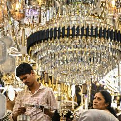 Los compradores miran lámparas de araña en una tienda de electrodomésticos en Bengaluru, India, mientras el primer ministro Narendra Modi implementa las nuevas reformas del Impuesto sobre Bienes y Servicios (GST), que reducen drásticamente los impuestos sobre los productos básicos y los abaratan para los consumidores antes de la temporada festiva en India. | Foto:IDREES MOHAMMED / AFP