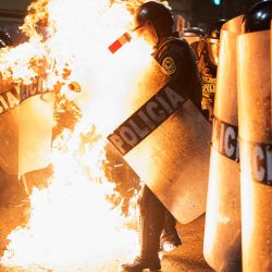 Un agente de la policía antidisturbios es alcanzado por una bomba molotov lanzada por manifestantes durante una manifestación antigubernamental en Lima, Perú. | Foto:ERNESTO BENAVIDES / AFP