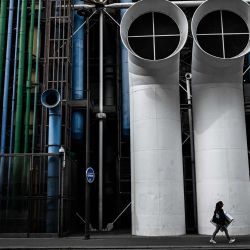 Una mujer pasa frente al Centro Nacional de Arte y Cultura Georges Pompidou, en el barrio de Beaubourg, París. | Foto:JULIEN DE ROSA / AFP