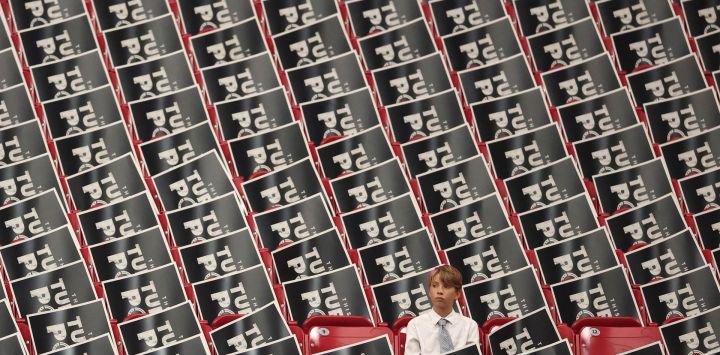 Un niño se sienta entre carteles en sillas antes del servicio conmemorativo público del activista de derecha Charlie Kirk en el estadio State Farm en Glendale, Arizona.