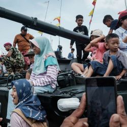 Los visitantes se toman fotografías con el equipo militar exhibido durante la Feria de las Fuerzas Armadas de Indonesia (TNI), que conmemora el 80 aniversario de las TNI, en el Monumento Nacional (Monas) en Yakarta. | Foto:Yasuyoshi Chiba / AFP