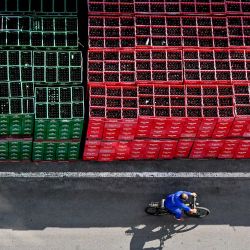 Un hombre pasa en bicicleta junto a barriles de cerveza en la Cervecería Hanoi, que produce la marca Hanoi Beer, propiedad de la empresa estatal Habeco, en Hanoi, Vietnam. | Foto:NHAC NGUYEN / AFP