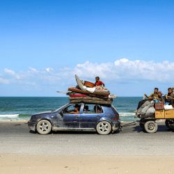 Un vehículo que remolca un carro y transporta a evacuados que huyen hacia el sur desde la ciudad de Gaza avanza por la carretera costera de Nuseirat, en el centro de la Franja de Gaza. Israel ha intensificado sus bombardeos sobre la ciudad de Gaza como preparación para su operación militar, a pesar de las reiteradas peticiones de los países occidentales y las agencias de ayuda para que cese. | Foto:Eyad Baba / AFP