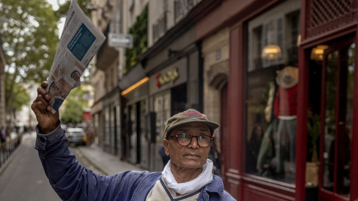 Pakistani born 73-year-old newspaper hawker Ali Akbar sells newspaper copies in the street of the Latin Quarter in Paris on September 16, 2025. 