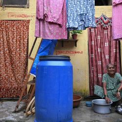 Esta fotografía muestra a una residente elegible para reubicación en el marco de un proyecto de renovación urbana, lavando utensilios frente a su casa, destinada a ser reurbanizada, en Dharavi, un asentamiento precario de Bombay. | Foto:Indranil Mukherjee / AFP