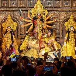Los devotos toman fotografías mientras visitan un 'Pandal' (estructura temporal para el culto) con un ídolo de la diosa hindú Durga en vísperas del festival 'Durga Puja' en Calcuta, India. | Foto:DIBYANGSHU SARKAR / AFP