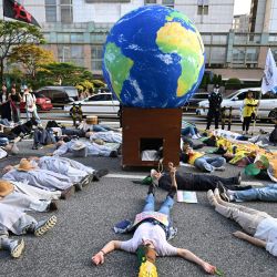 Manifestantes simulan estar muertos durante una manifestación por la justicia climática en Seúl, Corea del Sur. | Foto:Jung Yeon-je / AFP