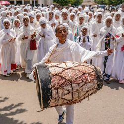 Un niño tocando el kebero dirige un coro juvenil por las calles de Asmara tras la celebración de Meskel en la plaza Bahti Meskerem de Asmara, Eritrea. La celebración de Meskel, en la Iglesia Ortodoxa de Eritrea y Etiopía, conmemora el descubrimiento de la Vera Cruz en el siglo IV por Santa Elena, madre del emperador Constantino. | Foto:JEMAL COUNTESS / AFP