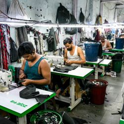 Esta fotografía muestra a sastres cosiendo ropa en una pequeña fábrica de ropa dentro de Dharavi, un asentamiento precario en Bombay. | Foto:Indranil Mukherjee / AFP