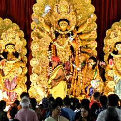 Los devotos observan a un sacerdote realizar rituales religiosos frente a un ídolo de la diosa hindú Durga en un lugar de culto temporal conocido como 'pandal' con motivo del festival Durga Puja en Bengaluru, India. | Foto:IDREES MOHAMMED / AFP