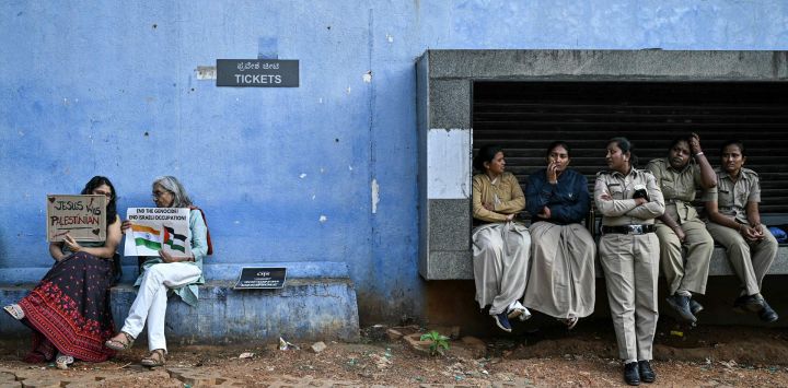 Manifestantes (izq.) con pancartas se sientan junto a la policía durante una protesta antiisraelí para expresar su solidaridad con los palestinos en el Parque de la Libertad de Bengaluru, India, en medio de la guerra en curso entre Israel y el grupo militante Hamás.