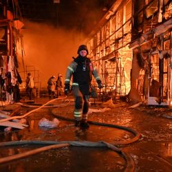 Bomberos ucranianos luchan por extinguir un incendio que asoló el mercado de Barabashovo tras un ataque aéreo en Járkov, durante la invasión rusa de Ucrania. | Foto:SERGEY BOBOK / AFP