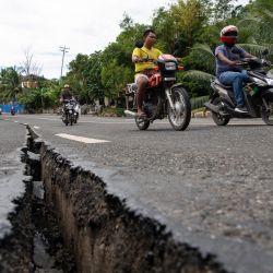 Los conductores pasan junto a una grieta en una carretera importante en la ciudad de Tabogon, provincia de Cebú, en el centro de Filipinas, tras un terremoto de magnitud 6,9 que azotó la costa central de Filipinas. | Foto:TED ALJIBE / AFP