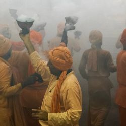 Los devotos hindúes interpretan Dhunuchi Naach, una forma de danza tradicional, frente a un ídolo de la diosa Durga durante un ritual religioso conocido como aarti, con motivo del festival Durga Puja en Varanasi, India. | Foto:NIHARIKA KULKARNI / AFP
