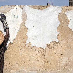 Un curtidor seca pieles en una pared de la curtiduría tradicional Majema, en el barrio de Kofar Wambai, Kano. Kano, el histórico centro del cuero, abastece a gigantes del lujo como Louis Vuitton, Gucci y Ralph Lauren, y Nigeria exporta casi el 90 % de sus pieles. Sin embargo, como el acabado se realiza en Europa, la etiqueta «Hecho en Nigeria» desaparece y se reemplaza por «Hecho en Italia» o «Hecho en España». Ahora, algunos diseñadores nigerianos intentan recuperar la identidad del cuero del país creando marcas locales. | Foto:OLYMPIA DE MAISMONT / AFP
