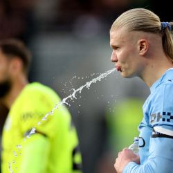 El delantero noruego del Manchester City, Erling Haaland, escupe agua durante el partido de la Premier League inglesa entre el Brentford y el Manchester City en el Gtech Community Stadium de Londres. | Foto:Adrian Dennis / AFP