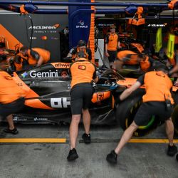 Los mecánicos practican en boxes con el piloto australiano de McLaren, Oscar Piastri, antes de la tercera sesión de entrenamientos libres previa a la carrera nocturna del Gran Premio de Fórmula 1 de Singapur en el circuito urbano de Marina Bay, Singapur. | Foto:Mohd Rasfan / AFP