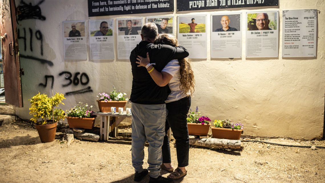 Two people embrace ahead of a memorial ceremony for the victims of the 2023 October 7 attacks at the Nova Festival grounds in Reim in southern Israel on the second anniversary of the attacks on October 7, 2025