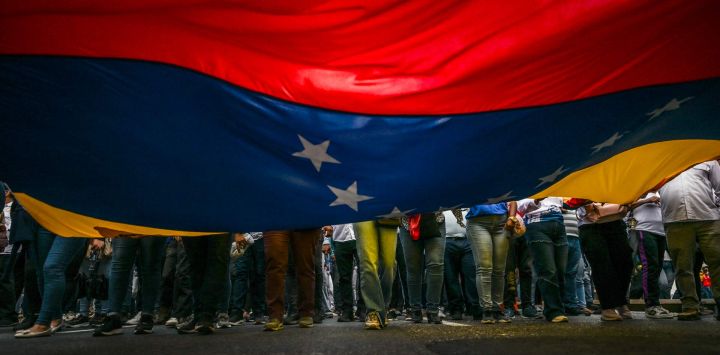 Partidarios del presidente venezolano, Nicolás Maduro, portan una bandera venezolana durante una protesta frente a la sede de las Naciones Unidas en Caracas. Venezuela declaró haber frustrado una operación de bandera falsa por parte de presuntos extremistas de derecha para colocar explosivos en la embajada de Estados Unidos en Caracas, en medio de un enfrentamiento entre ambos países por el narcotráfico.