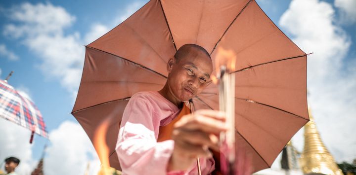 Una monja budista enciende incienso mientras visita la pagoda Shwedagon para conmemorar el día de luna llena del festival Thadingyut en Yangon.