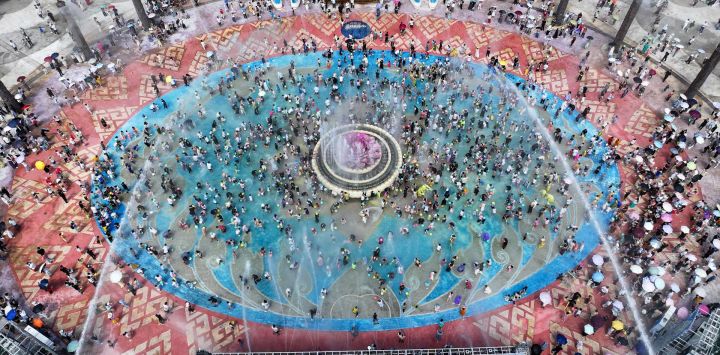 Vista aérea tomada con un dron de turistas participando en un evento de salpicaduras de agua en un punto escénico, en la ciudad de Jinghong, en la provincia de Yunnan, en el suroeste de China. Los destinos turísticos de toda China están experimentando un aumento en el número de visitantes desde que comenzó el feriado de ocho días por el Día Nacional y el Festival del Medio Otoño.