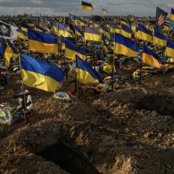 Esta fotografía muestra tumbas vacías rodeadas de banderas ucranianas que adornan las tumbas de los soldados caídos durante la invasión rusa de Ucrania, en la sección militar del cementerio Kharkic, en Járkov, este de Ucrania. | Foto:ED JONES / AFP