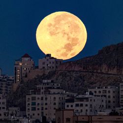 La luna llena se pone detrás del monte Eibal, como se ve desde Nablus, en la Cisjordania ocupada. | Foto:JAAFAR ASHTIYEH / AFP