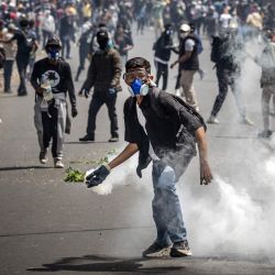 Un manifestante sostiene un bote de gas lacrimógeno mientras miles de personas se congregan durante los enfrentamientos entre manifestantes y fuerzas de seguridad en protestas que exigen la dimisión del presidente Andry Rajoelina en Antananarivo, Madagascar. | Foto:LUIS TATO / AFP
