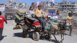 Personas desplazadas en Gaza transportan sus pertenencias en un carro tirado por burros