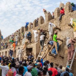 Los residentes suben por la pared con escaleras durante la restauración anual de la mezquita Djinguereber, también conocida como Djingareyber o Djingarey Ber, en Tombuctú. La restauración de 2025 marca el 700 aniversario de la construcción de esta mezquita, erigida en el siglo XIV durante el reinado del emperador Kankou Moussa. | Foto:Hameye Capii / AFP