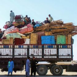 Refugiados afganos en ruta a Afganistán se sientan en un camión detenido con sus pertenencias, mientras esperan su deportación en la frontera entre Pakistán y Afganistán en Chaman, en medio de intensos enfrentamientos fronterizos entre ambos países. | Foto:Abdul Basit / AFP