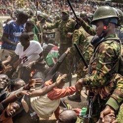 Agentes de la policía de Kenia controlan a la multitud mientras simpatizantes y dolientes se apiñan en una estampida a la entrada del Estadio Nyayo, donde el cuerpo del líder de la oposición y ex primer ministro Raila Odinga yace en velatorio público durante su funeral de Estado en Nairobi. | Foto:LUIS TATO / AFP
