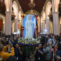 Fieles católicos portan una imagen de Sor Carmen Rendiles Martínez durante su ceremonia de canonización en la iglesia de Nuestra Señora de la Candelaria en Caracas, Venezuela. | Foto:Federico Parra / AFP