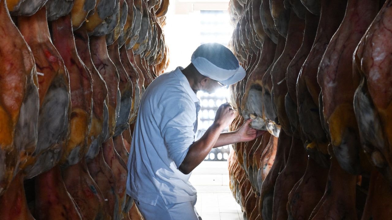 Un empleado controla la curación de los jamones en una de las fábricas de jamón de San Daniele, en San Daniele del Friuli, al noreste de Italia. | Foto:STEFANO RELLANDINI / AFP