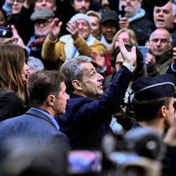 El expresidente francés Nicolas Sarkozy (centro) saluda a sus partidarios al salir de su residencia para presentarse en la prisión de La Santé, donde cumplirá una condena de cinco años de prisión tras ser declarado culpable de conspiración criminal por un plan para que el difunto dictador libio Muamar el Gadafi financiara su campaña electoral de 2007. | Foto:JULIEN DE ROSA / AFP