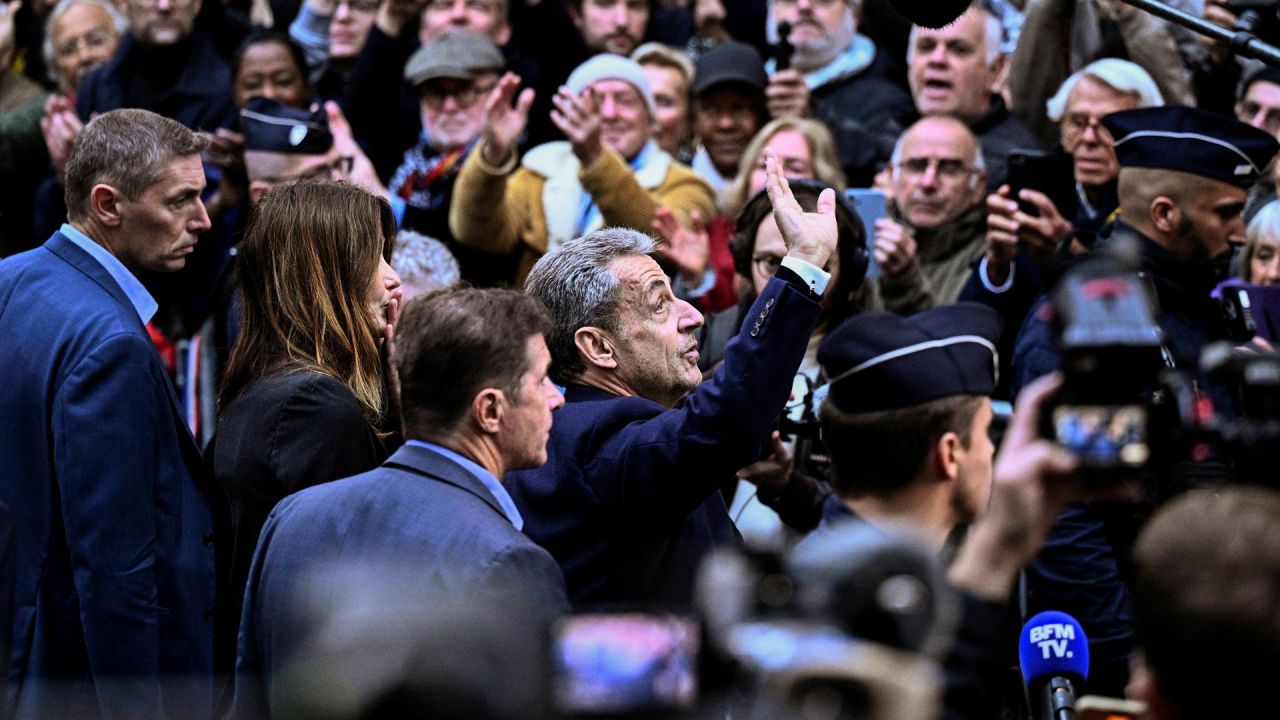 El expresidente francés Nicolas Sarkozy (centro) saluda a sus partidarios al salir de su residencia para presentarse en la prisión de La Santé, donde cumplirá una condena de cinco años de prisión tras ser declarado culpable de conspiración criminal por un plan para que el difunto dictador libio Muamar el Gadafi financiara su campaña electoral de 2007. | Foto:JULIEN DE ROSA / AFP