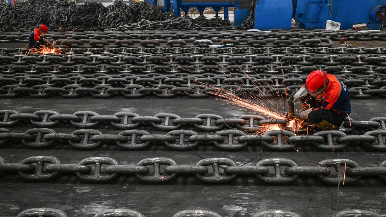 Los empleados fabrican cadenas de ancla en la línea de producción de Zhongyun Marine Equipment en Suqian, en la provincia oriental china de Jiangsu. | Foto:STR / AFP