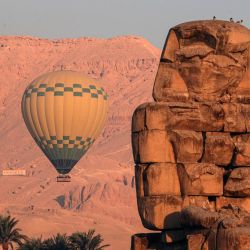Un globo aerostático es visto cerca de los Colosos de Memnón en la ribera occidental del río Nilo, en Luxor, Egipto. Luxor, capital del antiguo Alto Egipto conocida como Tebas, es un destino turístico famoso por sus edificios históricos del templo y otras reliquias. Hoy en día los viajes en globo aerostático son una opción popular para los turistas que visitan Luxor. | Foto:Xinhua/Ahmed Gomaa