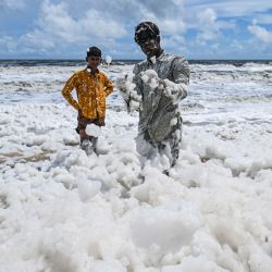 Unos niños juegan con una espesa y tóxica capa de espuma blanca que obstruye la contaminada playa Marina de Chennai, India. | Foto:R. Satish Babu / AFP