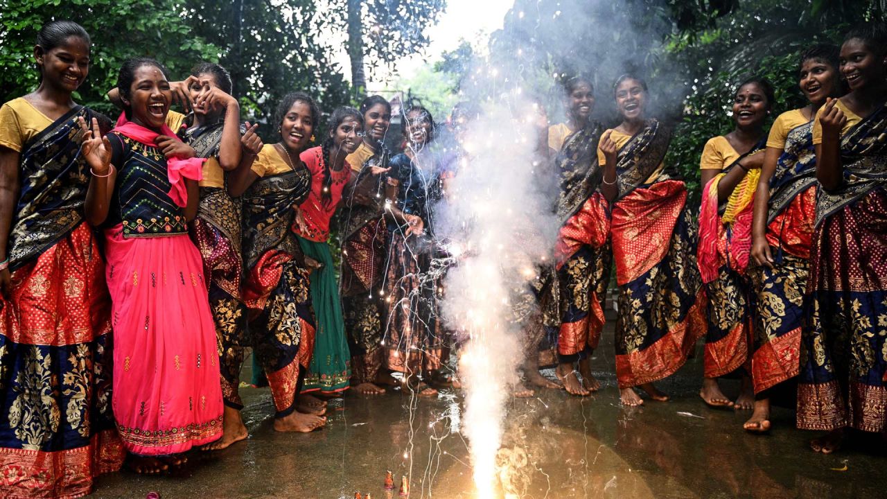 Mujeres encienden petardos durante las celebraciones en vísperas de Diwali, el festival hindú de las luces, en la residencia de una escuela en Chennai, India. | Foto:R. Satish Babu / AFP