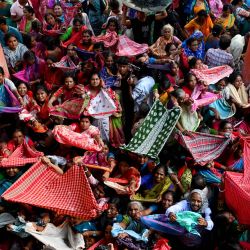 Devotos hindúes recogen ofrendas de arroz distribuidas con motivo del festival 'Annakut' o 'Govardhan Puja' en el templo Madan Mohan en Calcuta, India. | Foto:DIBYANGSHU SARKAR / AFP