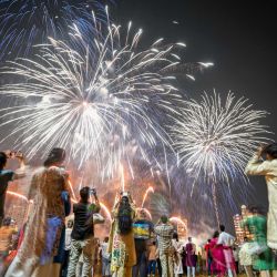 Los residentes locales observan los fuegos artificiales que iluminan el cielo como parte de las celebraciones de Diwali, el festival hindú de las luces, en Mumbai, India. | Foto:PUNIT PARANJPE / AFP
