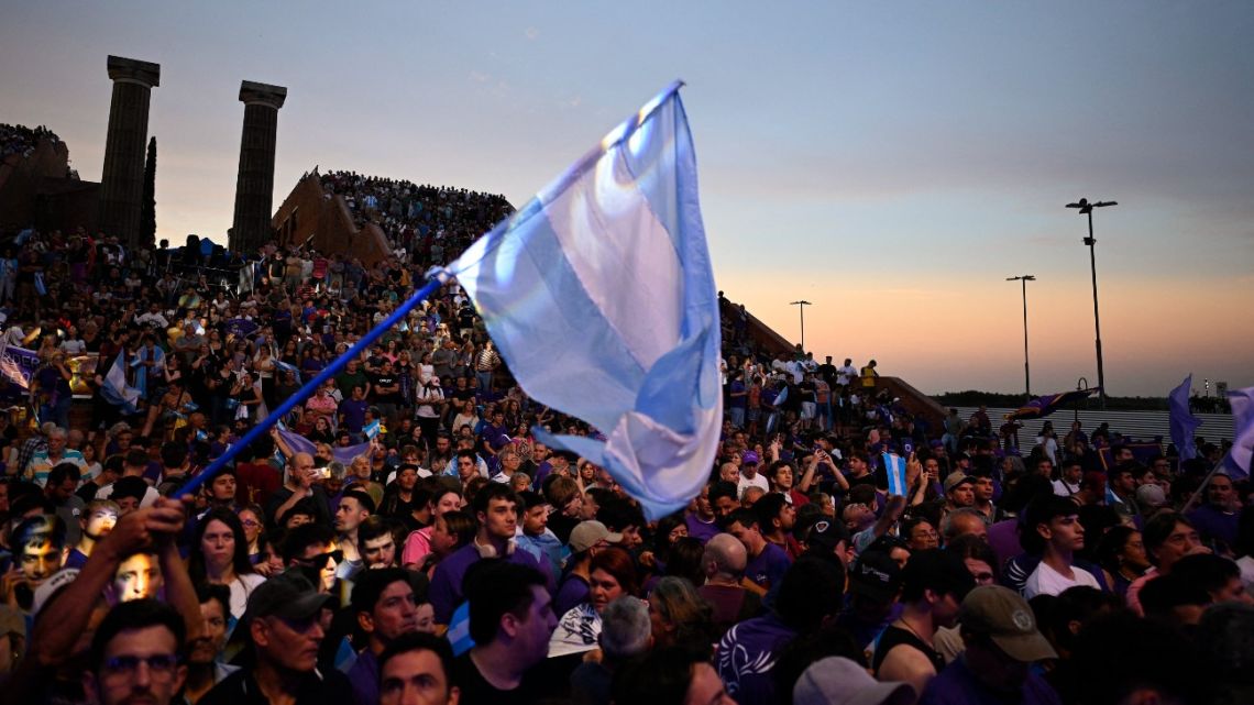 Supporters of Argentina's President Javier Milei wave an Argentine flag during the closing campaign rally of Libertad Avanza party ahead of the upcoming legislative elections in Rosario, Santa Fe province, Argentina on October 23, 2025.
