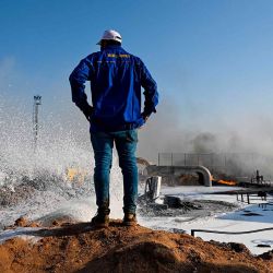 Un empleado de la Compañía Petrolera de Basora observa cómo los bomberos rocían espuma por un incendio que en el campo petrolífero de Zubair, Irak. Foto de Hussein FALEH / AFP | Foto:AFP