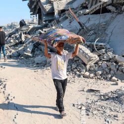 Un niño palestino con sus pertenencias camina entre los escombros de los edificios destruidos en el barrio de Al-Tuffah, en la ciudad de Gaza. Foto de Omar AL-QATTAA / AFP | Foto:AFP